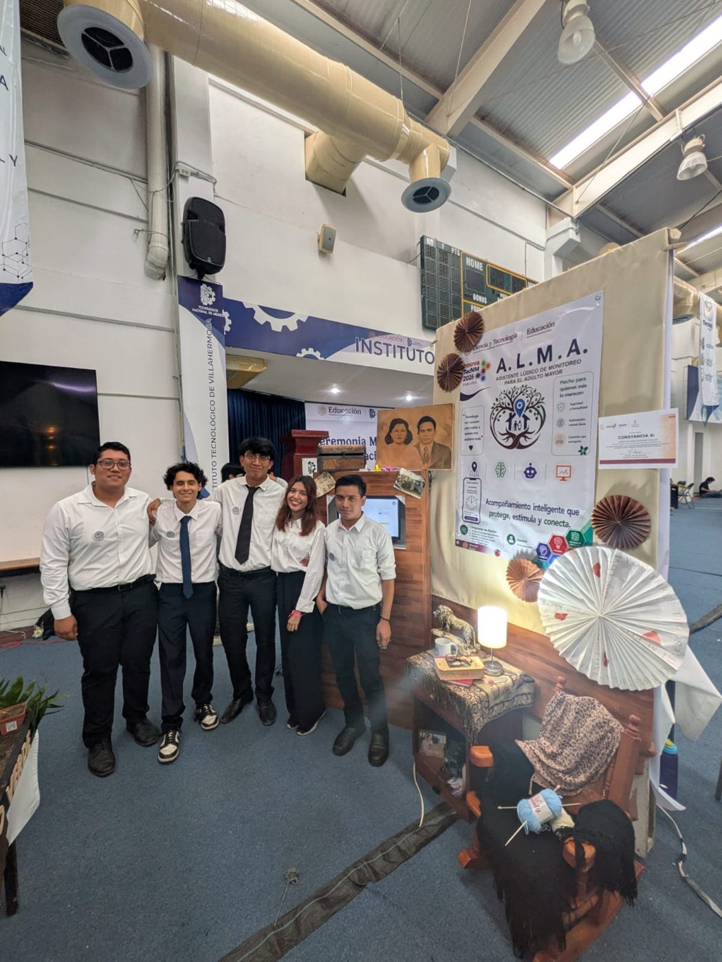 El equipo de A.L.M.A. posando junto al stand del proyecto